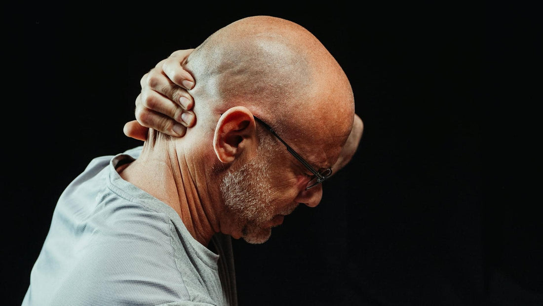 Evil Eye in the Body — close-up of a man holding his neck in pain