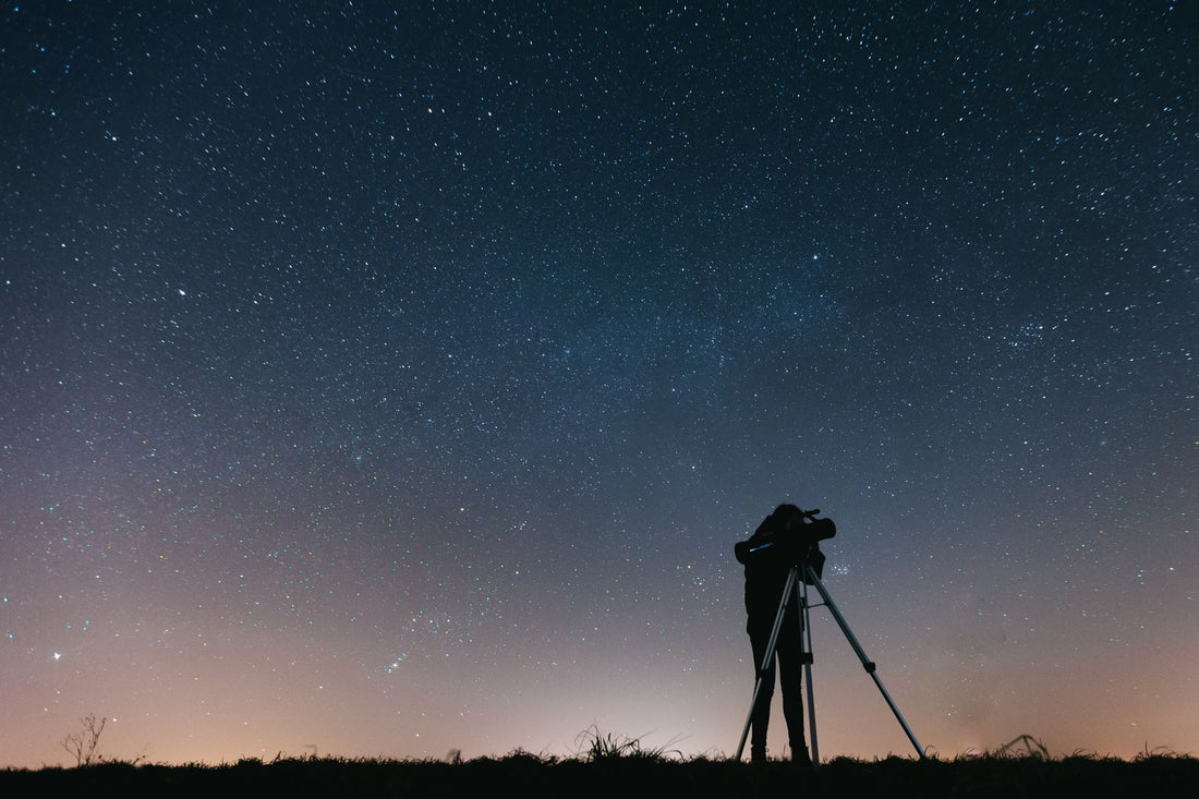 Silhouette of a single observer standing under a wide starry sky, evoking the relationship between attention and the field being observed